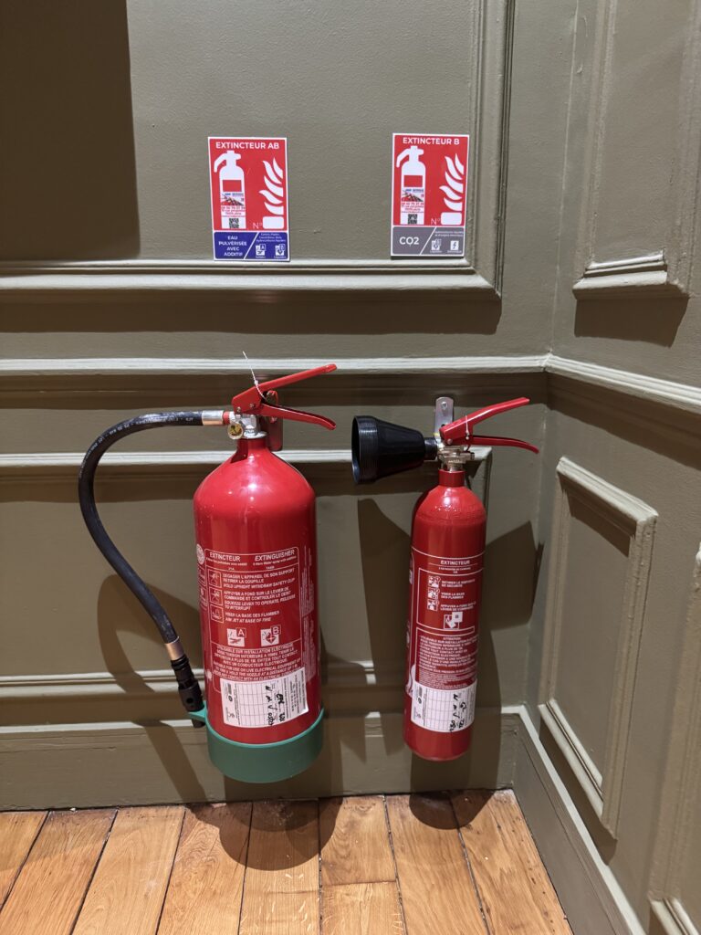 Étiquette de sécurité incendie apposée sur un extincteur AB